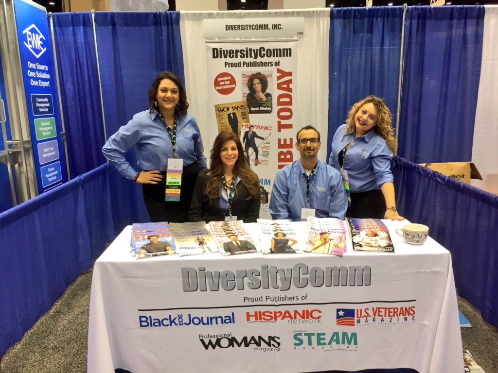 Mona Lisa Faris and her team members manning a DiversityComm information booth at a conference expo.